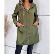 Giacca verde oliva con cappuccio, bottoni frontali, tasche laterali, indossata da donna. Moda autunnale, abbigliamento casual elegante.