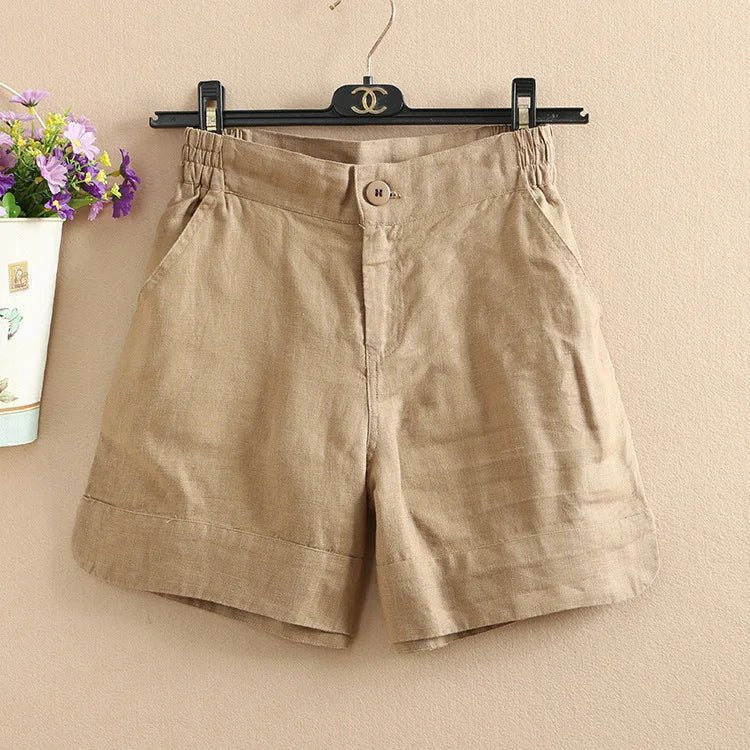 Pantaloncini beige in lino da donna, con tasche laterali e bottone frontale, appesi su gruccia. Eleganti e casual, ideali per l'estate.