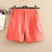 Pantaloncini donna in lino rosa corallo, elasticizzati in vita, con tasche laterali, appesi su gruccia. Ideali per estate e moda casual.