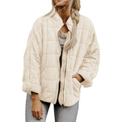 Giacca trapuntata beige da donna, stile casual, con zip frontale e maniche lunghe, indossata su jeans. Moda autunnale, abbigliamento femminile trendy.