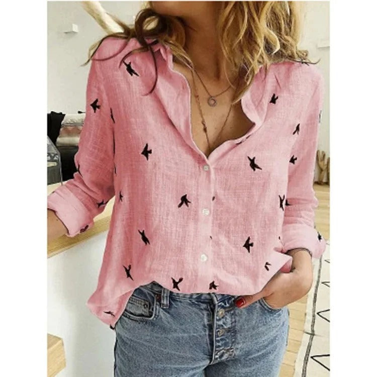 Camicia rosa donna con stampa uccelli neri, maniche lunghe, abbinata a jeans. Moda casual, stile primaverile, tessuto leggero e traspirante.