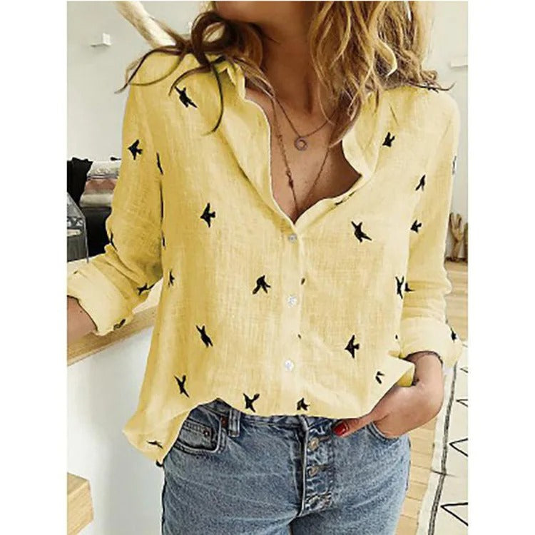 Camicia gialla con stampa di uccelli neri, maniche lunghe arrotolate, abbinata a jeans a vita alta. Stile casual, moda donna, abbigliamento estivo.