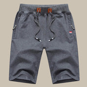 Pantaloncini sportivi grigi da uomo, con coulisse e tasche laterali, design casual, tessuto morbido, ideali per attività all'aperto e tempo libero.