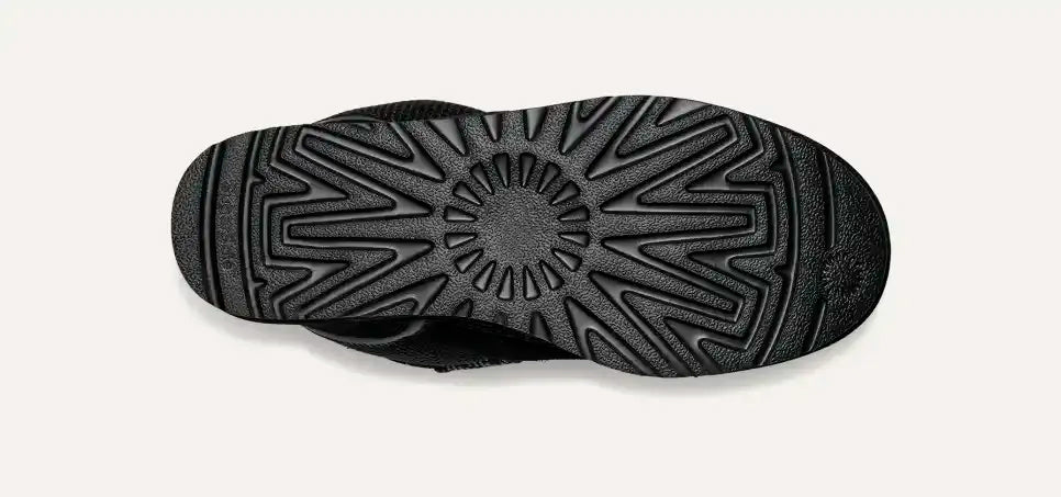 Suola di scarpa nera in gomma con motivo antiscivolo, vista dall'alto. Design resistente, ideale per calzature sportive e casual.