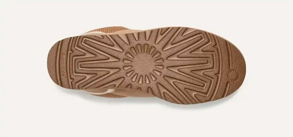 Suola di scarpa in gomma marrone con motivo antiscivolo geometrico, vista dall'alto. Design resistente e durevole per calzature outdoor.