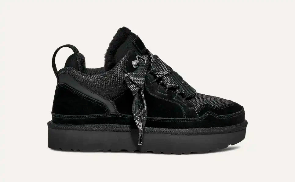 Scarpa da ginnastica nera invernale con suola spessa, lacci robusti e dettagli in tessuto e pelle. Design moderno e confortevole per il freddo.