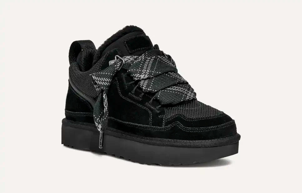 Scarpa da ginnastica nera in pelle scamosciata con suola spessa, lacci intrecciati grigi e neri, design moderno. Scarpe sportive eleganti uomo.
