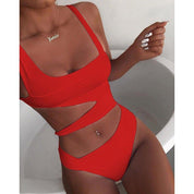Donna in costume da bagno rosso a due pezzi con design cut-out, collana personalizzata, unghie bianche. Moda mare estiva, tendenze beachwear.