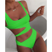 Costume da bagno intero verde neon con cut-out, design moderno, indossato da una donna. Perfetto per l'estate e la spiaggia.