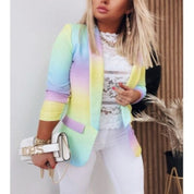 Giacca donna multicolore pastello, abbinata a top in pizzo bianco e pantaloni bianchi. Accessorio: borsa bianca con catena dorata. Moda elegante.