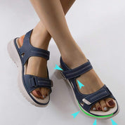 Sandali ortopedici da donna blu con chiusura a strappo, suola antiscivolo e design ergonomico. Calzature comode per camminate estive.