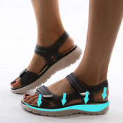 Sandali ortopedici neri da donna con suola ammortizzante, chiusura a strappo, design ergonomico per comfort e supporto plantare.