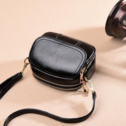 Borsa a tracolla in pelle nera lucida con cerniera dorata, design compatto e moderno, ideale per moda donna, accessori eleganti e versatili.