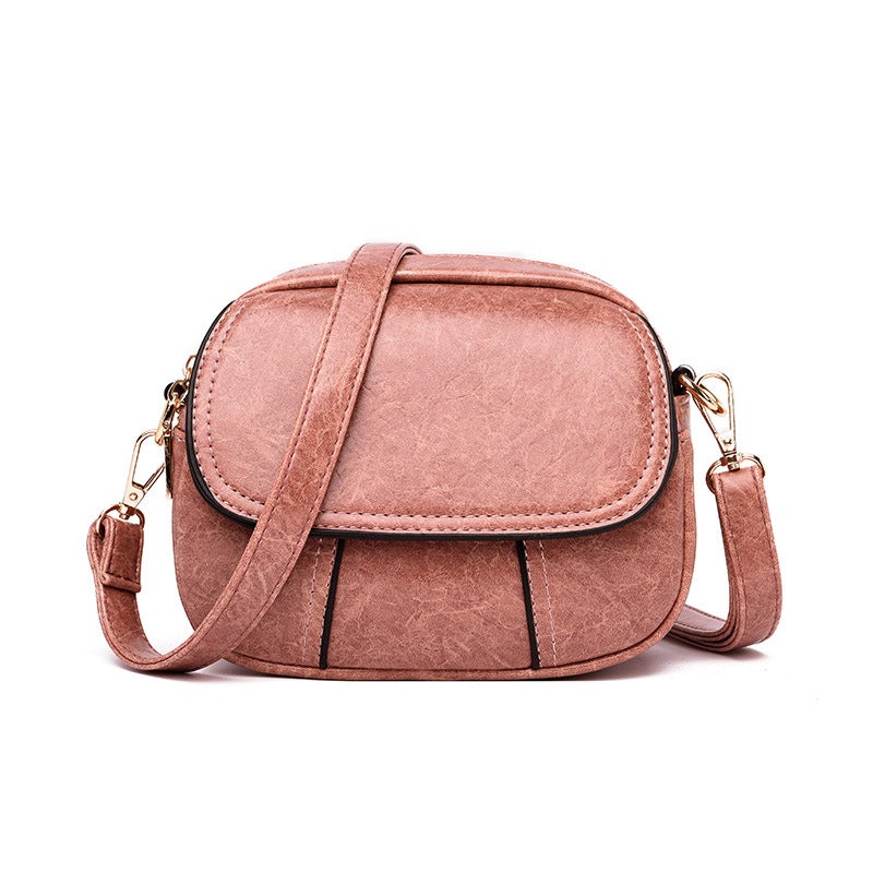 Borsa a tracolla in pelle rosa, design elegante e compatto, con chiusura a zip e dettagli in metallo dorato. Accessorio moda donna.