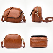 Borsa a tracolla in pelle marrone, design elegante e compatto, con cerniera dorata e tasca frontale. Accessorio moda donna, versatile e chic.