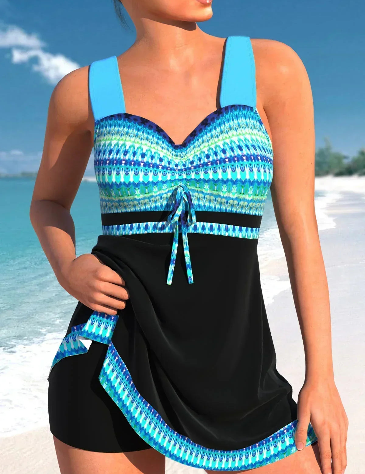 Donna in costume da bagno intero blu e nero con motivo geometrico, su spiaggia tropicale. Moda mare, abbigliamento estivo, vacanze al mare.