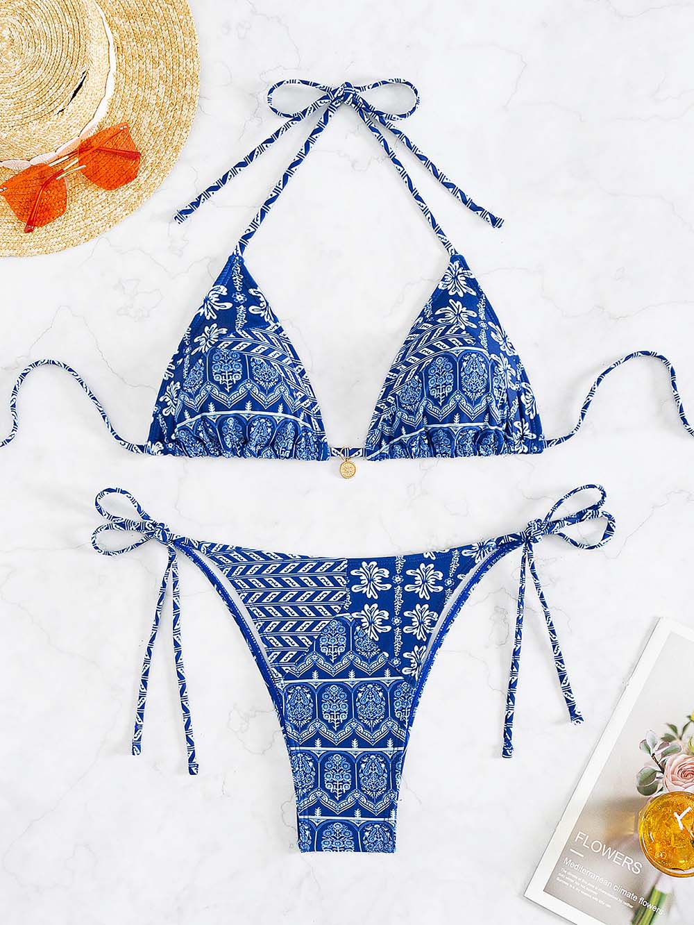 Bikini blu a triangolo con stampa floreale, laccetti regolabili, su sfondo bianco. Perfetto per l'estate e la spiaggia. Cappello e rivista inclusi.