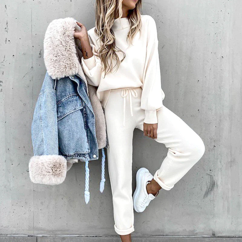 Donna in tuta bianca casual, con giacca di jeans foderata in pelliccia, scarpe da ginnastica bianche. Moda autunnale, abbigliamento comodo e trendy.